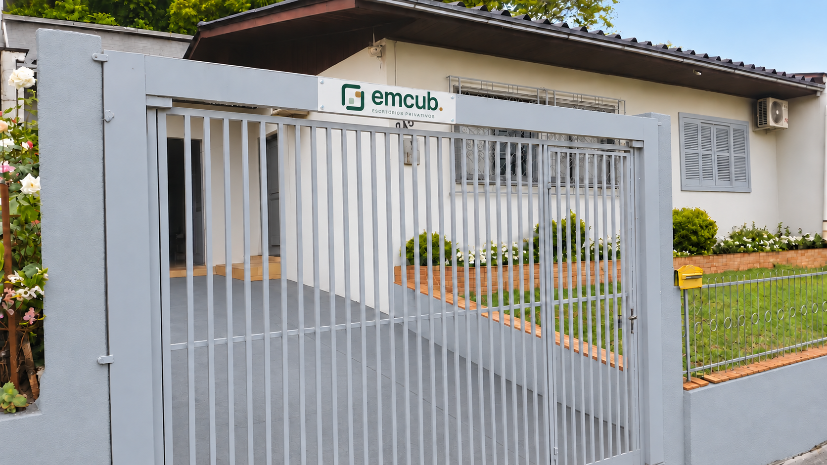 Fachada com placa emcub, janela e muro cinza, piso da garagem pintado e jardim cuidado